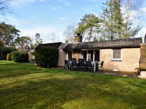 uma casa com cadeiras e uma mesa no quintal em Appealing Holiday Home in Guelders near Forest em Lochem