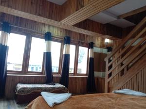 1 dormitorio con 2 camas en una habitación con ventanas en Odyssey's Darap Eco Retreat, en Pelling