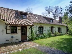 een oud wit huis met een grasveld ervoor bij Magnificent Farmhouse in Sint Joost in Sint Joost