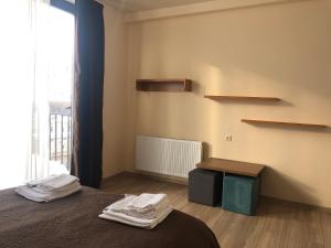 a bedroom with a bed and shelves and a window at Hotel Horizon Kazbegi in Kazbegi