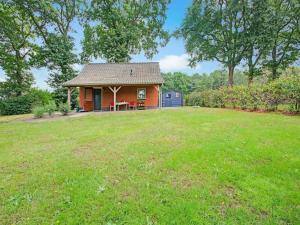 ein kleines Haus in einem Hof mit einem Grasfeld in der Unterkunft Holiday cottage in Schijf with a fenced garden in Schijf