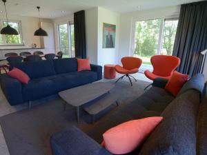WestermientにあるPeaceful Villa in De Koog near Seaのリビングルーム(青いソファ、オレンジの椅子付)