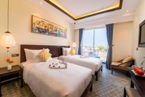会安Hoi An Merrily De Art Hotel的有两张床和一个阳台的酒店房间