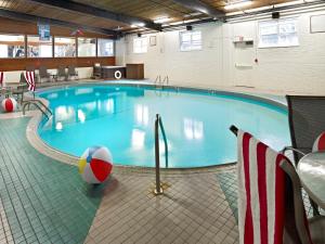 a swimming pool with a pool table and chairs at Charlottetown Inn & Conference Centre in Charlottetown