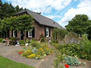 a garden in front of a house with flowers at Spacious holiday farm in Bronckhorst with private garden in Bronkhorst