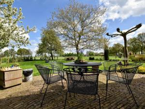a patio with a table and chairs in a park at Spacious holiday farm in Bronckhorst with private garden in Bronkhorst