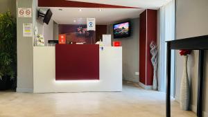 a store with a red and white counter in a room at Hotel Martinez Grenay in Grenay