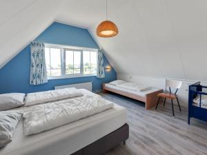 1 dormitorio con cama y pared azul en Beautiful dune villa with thatched roof on Ameland en Buren