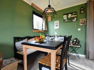 uma sala de jantar com uma mesa com uma taça de fruta em Tasteful chalet with veranda in the Veluwe em Garderen