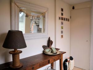 uma lâmpada sobre uma mesa com um espelho e pinguins em Cosy Holiday Home in Noordwijkerhout near Lake em Noordwijkerhout
