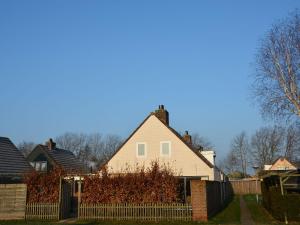 uma casa branca com uma cerca num quintal em Cosy Holiday Home in Noordwijkerhout near Lake em Noordwijkerhout