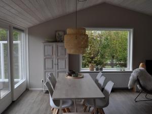 a dining room with a table and chairs and a window at bungalow situated directly at a large sand dunes in Ballum