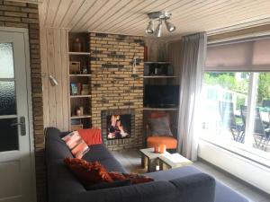 een woonkamer met een bank en een open haard bij Secluded Holiday Home in Ballum Frisian Islands in Ballum