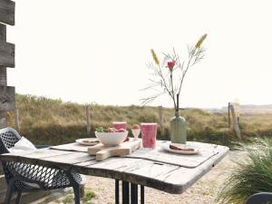uma mesa de madeira com comida e um vaso sobre ela em Modern suites near beach em Callantsoog