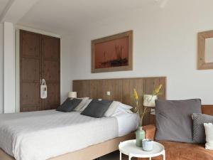 um quarto com uma cama grande e um sofá em Modern suites near beach em Callantsoog