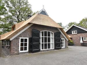 um pequeno edifício de tijolos com telhado de palha em Villa on an Estate in Rheezerveen with Garden em Rheezerveen