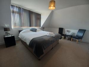 1 dormitorio con cama, escritorio y silla en The Westby, en Bournemouth