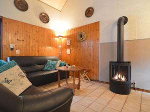 a living room with a couch and a fireplace at Cozy Holiday Home in Uden with huge private garden in Uden