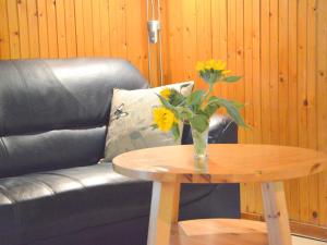 um vaso de flores numa mesa ao lado de um sofá em Cozy Holiday Home in Uden with huge private garden em Uden