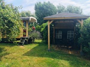 een tuinhuisje en een huis in een tuin bij Holiday Home in Bergen op Zoom with Garden in Bergen op Zoom