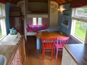 eine kleine Küche mit einem Tisch und Stühlen in einem Wohnwagen in der Unterkunft Holiday Home in Bergen op Zoom with Garden in Bergen op Zoom
