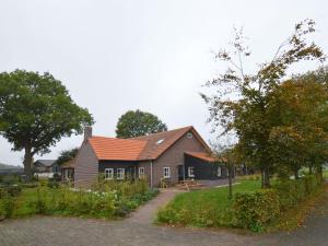 een huis met een oranje dak op een straat bij Cosy holiday home on a farm in Zeeland in Zeeland