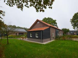 een klein huis in een tuin met een groen gazon bij Cosy holiday home on a farm in Zeeland in Zeeland