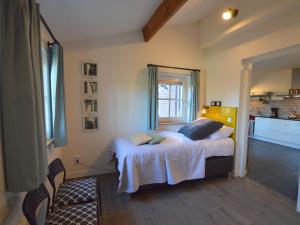 een slaapkamer met een bed en een keuken bij Cosy holiday home on a farm in Zeeland in Zeeland