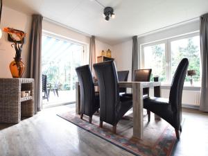 a dining room with a table and black chairs at Holiday Home in Reutum Weerselo with Jacuzzi in Beekdorp