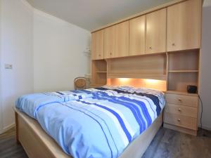 1 dormitorio con 1 cama y armarios de madera en Holiday Home in Reutum Weerselo with Jacuzzi, en Beekdorp