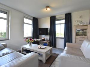 a living room with a couch and a table at house in a quiet park with sauna in Breskens