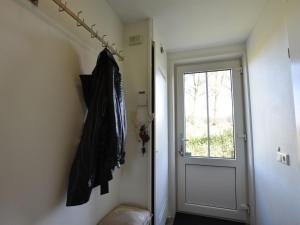 a hallway with a door and a coat hanging on the wall at house in a quiet park with sauna in Breskens