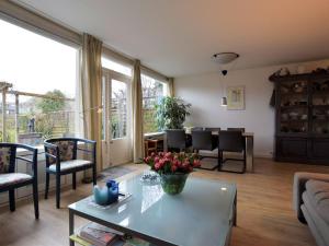 a living room with a table with flowers on it at Terrace Apartment with Lush Garden in Voorburg +27 photos