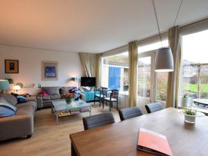 a living room with a couch and a table at Terrace Apartment with Lush Garden in Voorburg