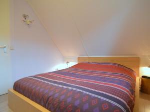 a bedroom with a bed with a striped blanket at Beautiful Holiday Home in Heeten with Private Garden in Heeten