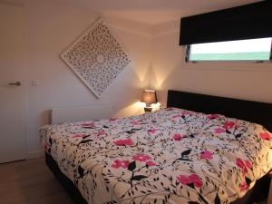 KattendijkeにあるComfortable holiday home nearby Oosterscheldeのベッドルーム1室(花柄の掛け布団付きのベッド1台付)