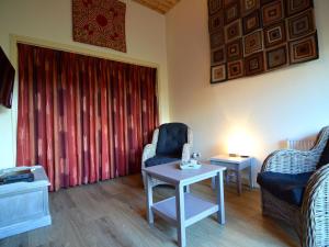 een woonkamer met 2 stoelen en een tafel bij Staying in a thatched barn with bedroom and box bed beautiful view Achterhoek in Geesteren