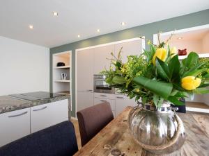 eine Vase mit Blumen auf einem Holztisch in der Küche in der Unterkunft Beautiful houseboat with terrace jacuzzi in Den Haag