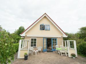 スコールルにあるHoliday Home in Schoorl with Fencedの白い椅子と青い扉のある家