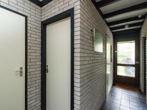 een hal met een deur en een bakstenen muur bij Comfortable detached bungalow 65 m2 in Kamperland