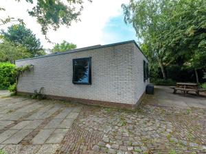 een bakstenen gebouw met een raam op een patio bij Comfortable detached bungalow 65 m2 in Kamperland