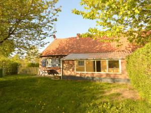 una piccola casa in mattoni con una panchina nel cortile di Holiday home in North Limburg with enclosed garden a Ospel