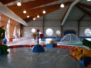 un grand parc aquatique intérieur avec une piscine dotée d'un toboggan. dans l'établissement Comfortable waterside holiday villa, à Biddinghuizen