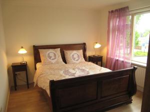 een slaapkamer met een bed met 2 lampen en een raam bij Tranquil holiday home in West Gradijk in West-Graftdijk