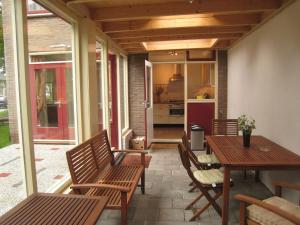 un patio con tavolo e sedie e una cucina di Tranquil holiday home in West Gradijk a West-Graftdijk