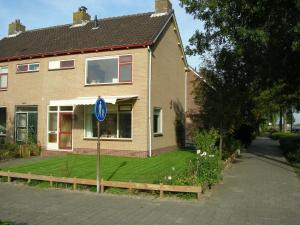 una casa con un cartello blu davanti di Tranquil holiday home in West Gradijk a West-Graftdijk