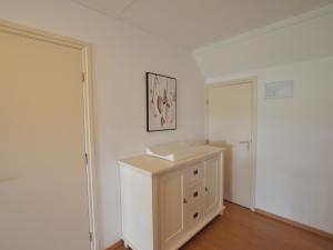 a white room with a cabinet and a door at Linked farm in Elsendorp with a recreation barn in Elsendorp