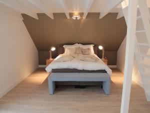 um quarto com uma cama num sótão em Elegant Farmhouse in Zuidzande with Private Garden em Zuidzande