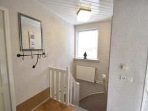 ホルテンにあるLovely holiday home in Rijssen Holten with gardenの鏡と窓のある階段付きの客室です。