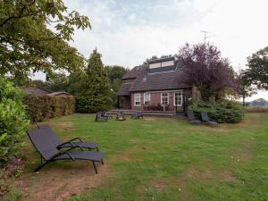 ein Haus mit einem Garten mit Stühlen davor in der Unterkunft Authentic Holiday Home in North Brabant by the Forest in Leende